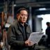 香港三级片知名导演邱礼涛，专注类型电影创作，手持剧本在片场指导演员，神情专注认真